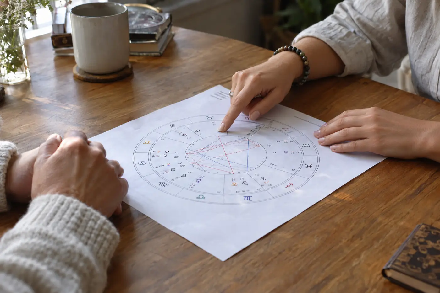 Jessica går igenom en astrologisk karta vid köksbordet